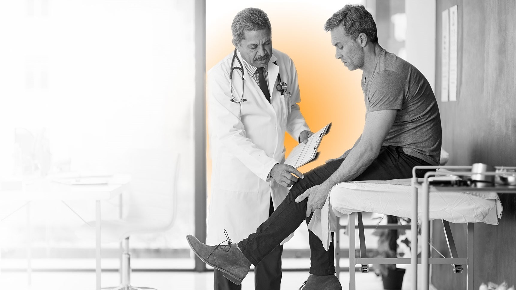 Un m&eacute;dico evaluando la rodilla de su paciente.