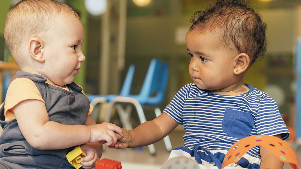 Two toddlers playing together at preschool.