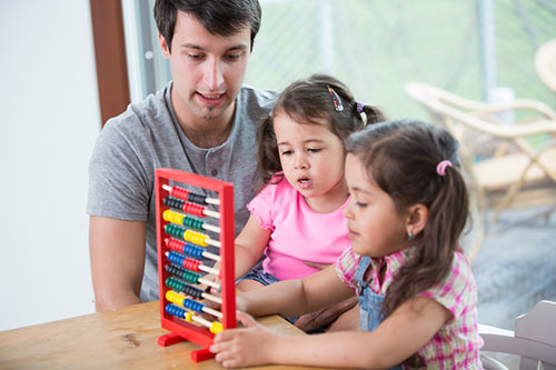 dad-daughters-toy-500px.jpg Padre con sus hijas jugando con un juguete