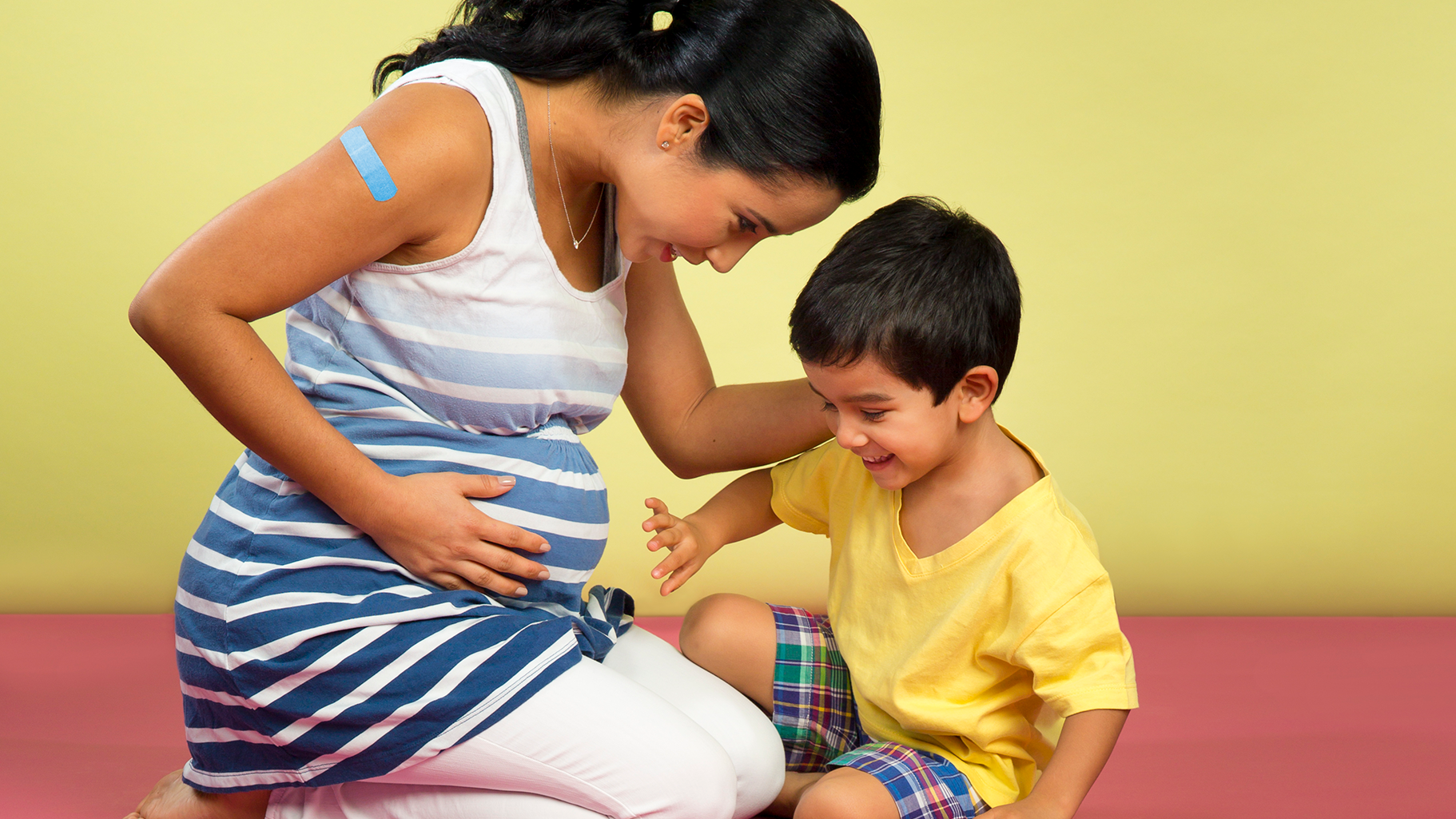 Madre embarazada sentada con su hijo.