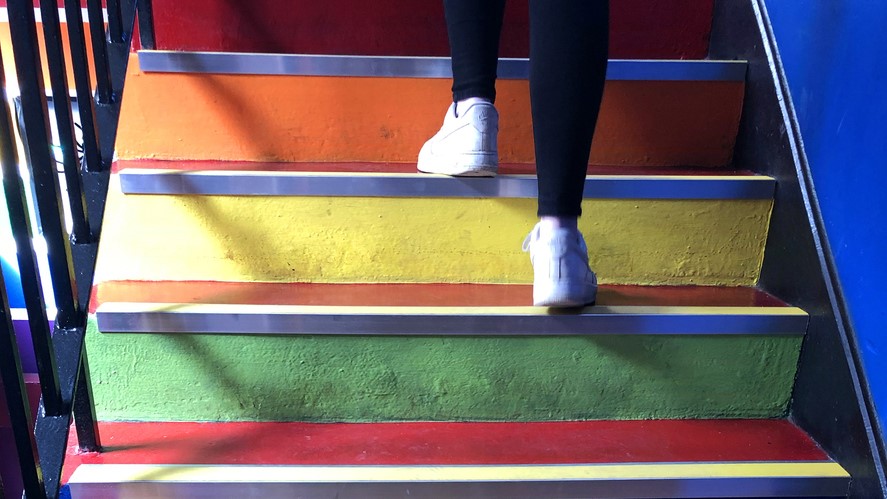 Person's feet walking up a colorful staircase A person's feet walking up a colorful staircase.