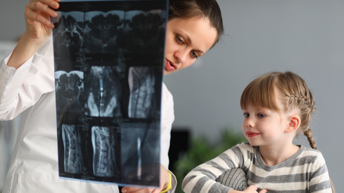 Pediatrician showing a little girl an x-ray.