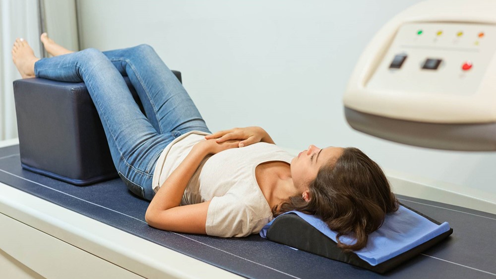 Woman being scanned by a bone density scanner.