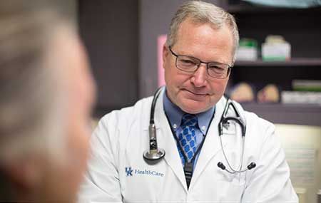Photo of Dr. Timothy Mullett talking with patient.