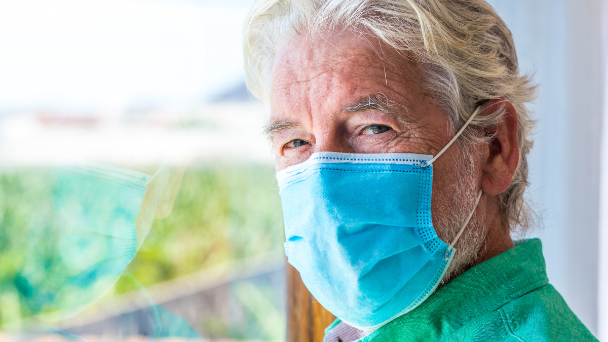 Older male wearing a face mask.