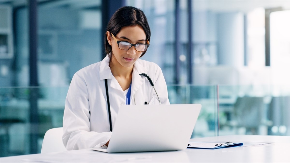 Healthcare provider using notebook computer in office.