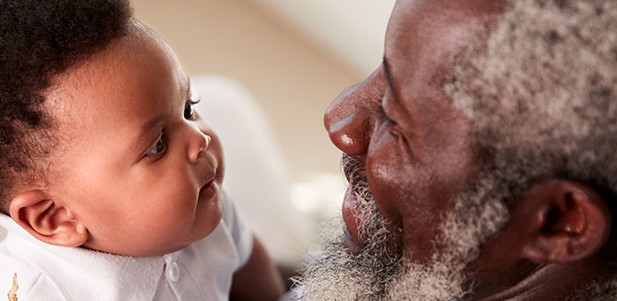 Un abuelo sosteniendo a un beb&eacute;