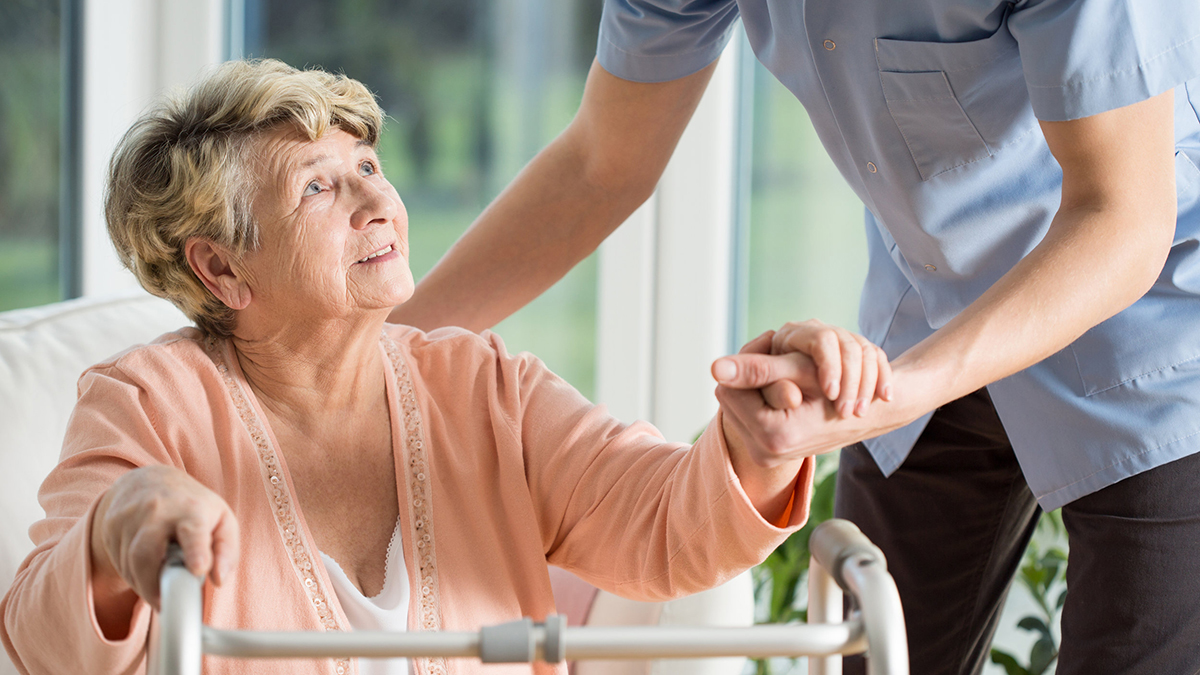 Older woman with a walker getting help
