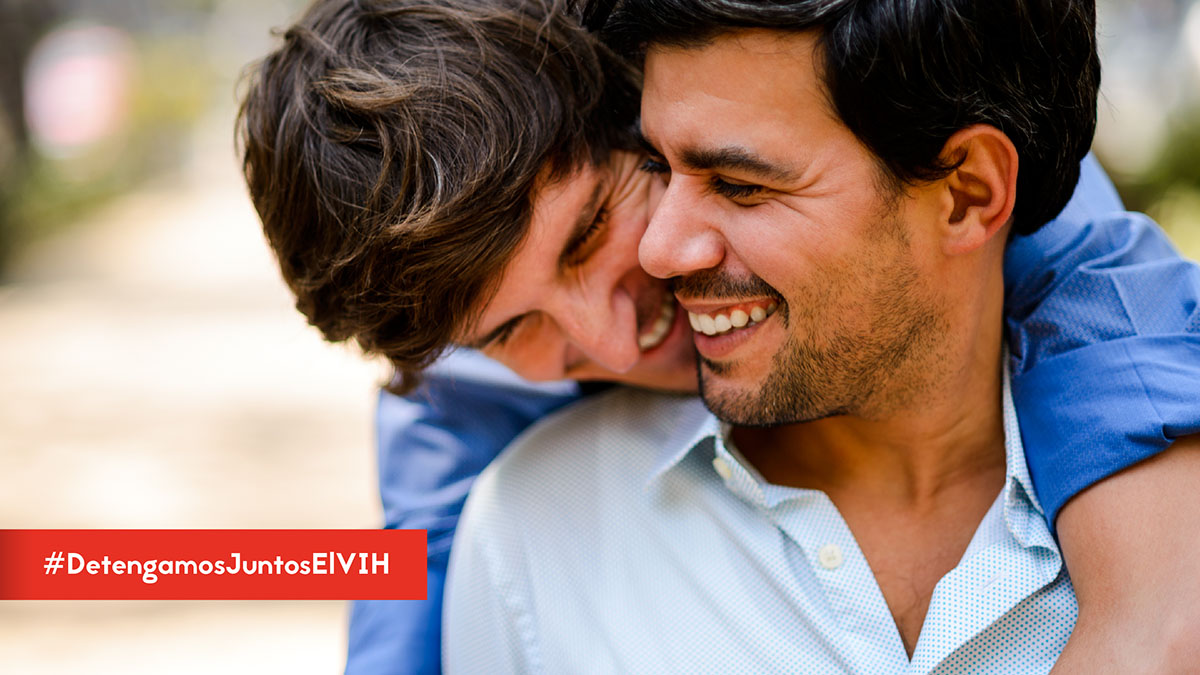 TwitterPosts-STSH-HTW-2020 Comenzar el tratamiento es el paso más importante después del diagnóstico del #VIH. Puedes mantenerte saludable si lo empiezas lo más pronto posible. Aprende más: https://bit.ly/2ZqGYXT #DetengamosJuntosElVIH - Two men smiling with one hugging the other from behind