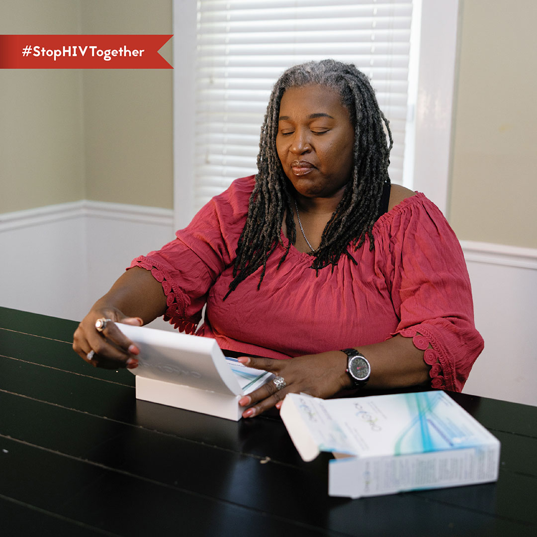 Self-Testing – Orisha An image of a woman opening an HIV self-test kit.