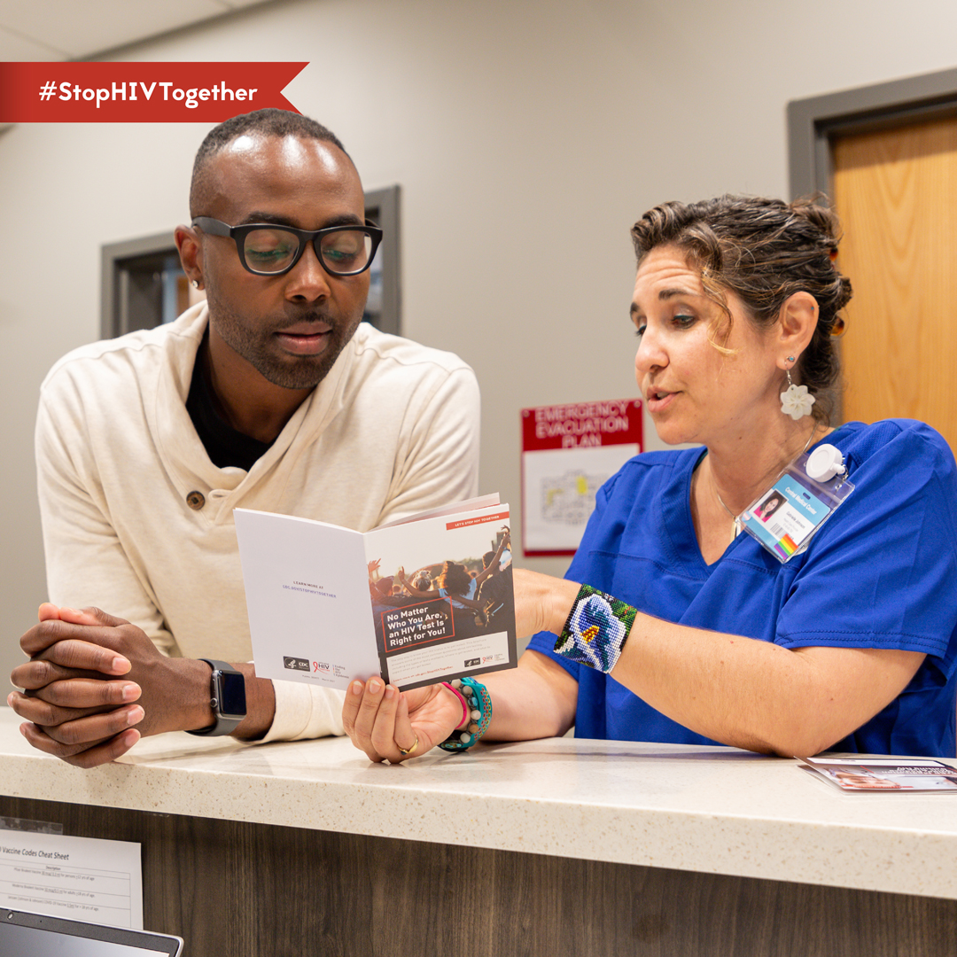 Patient-Provider Convo An image of a provider conversing with a patient and reading from a pamphlet.
