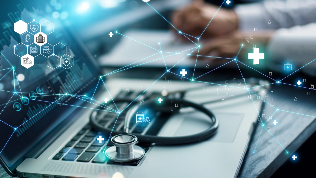 A health care provider on a laptop with graphic elements overlapping.