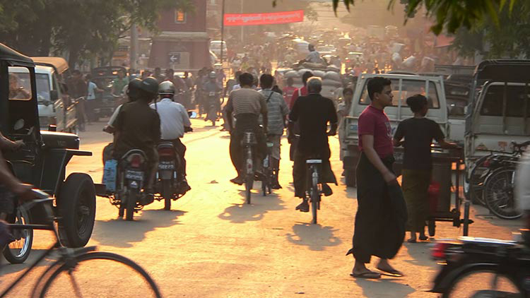 Global road safety thumbail People walking and riding bicycles on a busy street in Mandalay