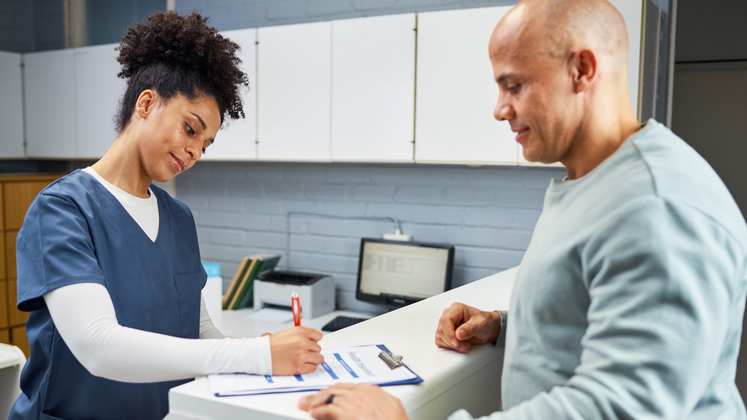 Image of health care provider and patient completing a form