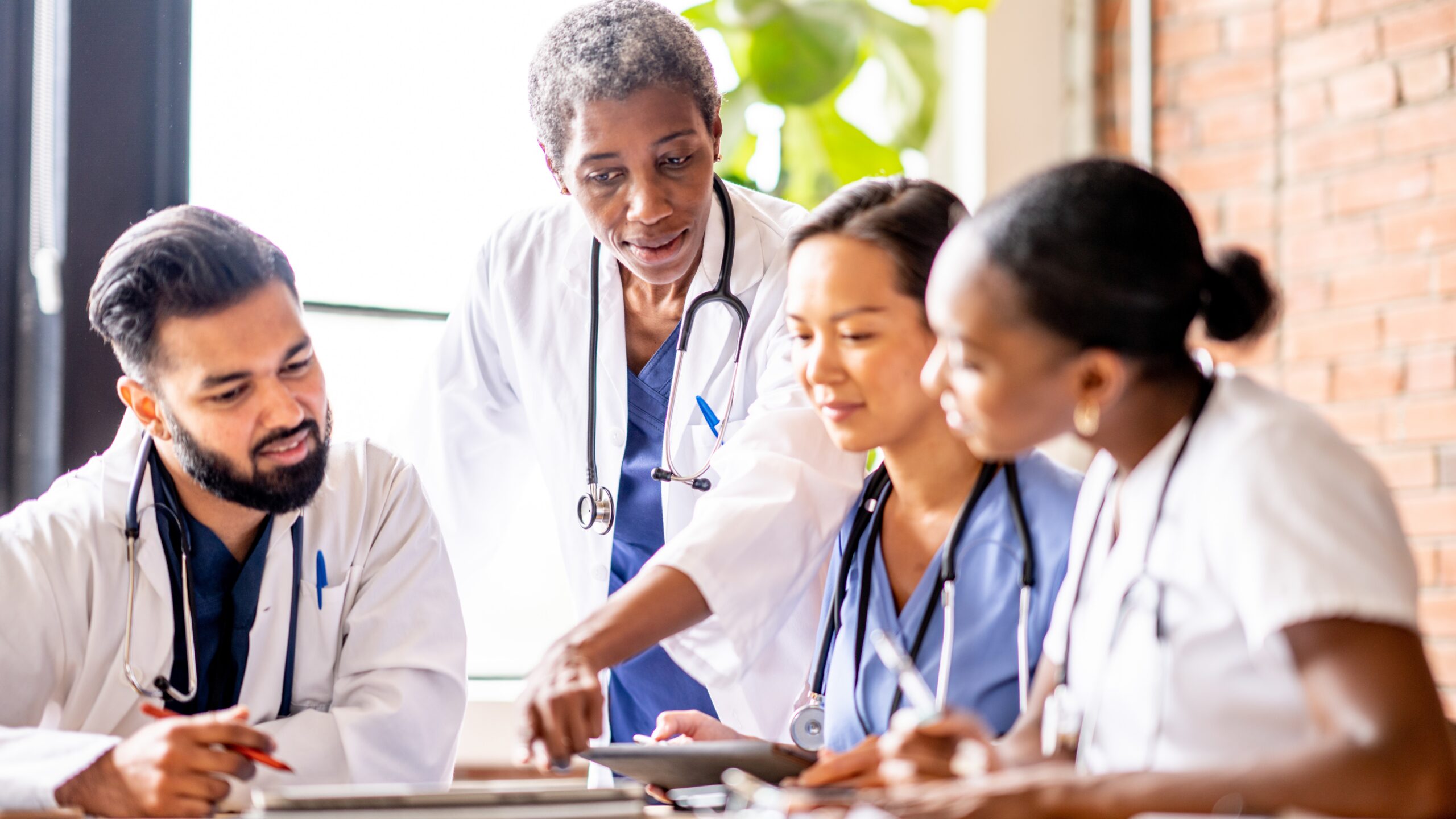 Health care professionals at a table discussing amongst each other