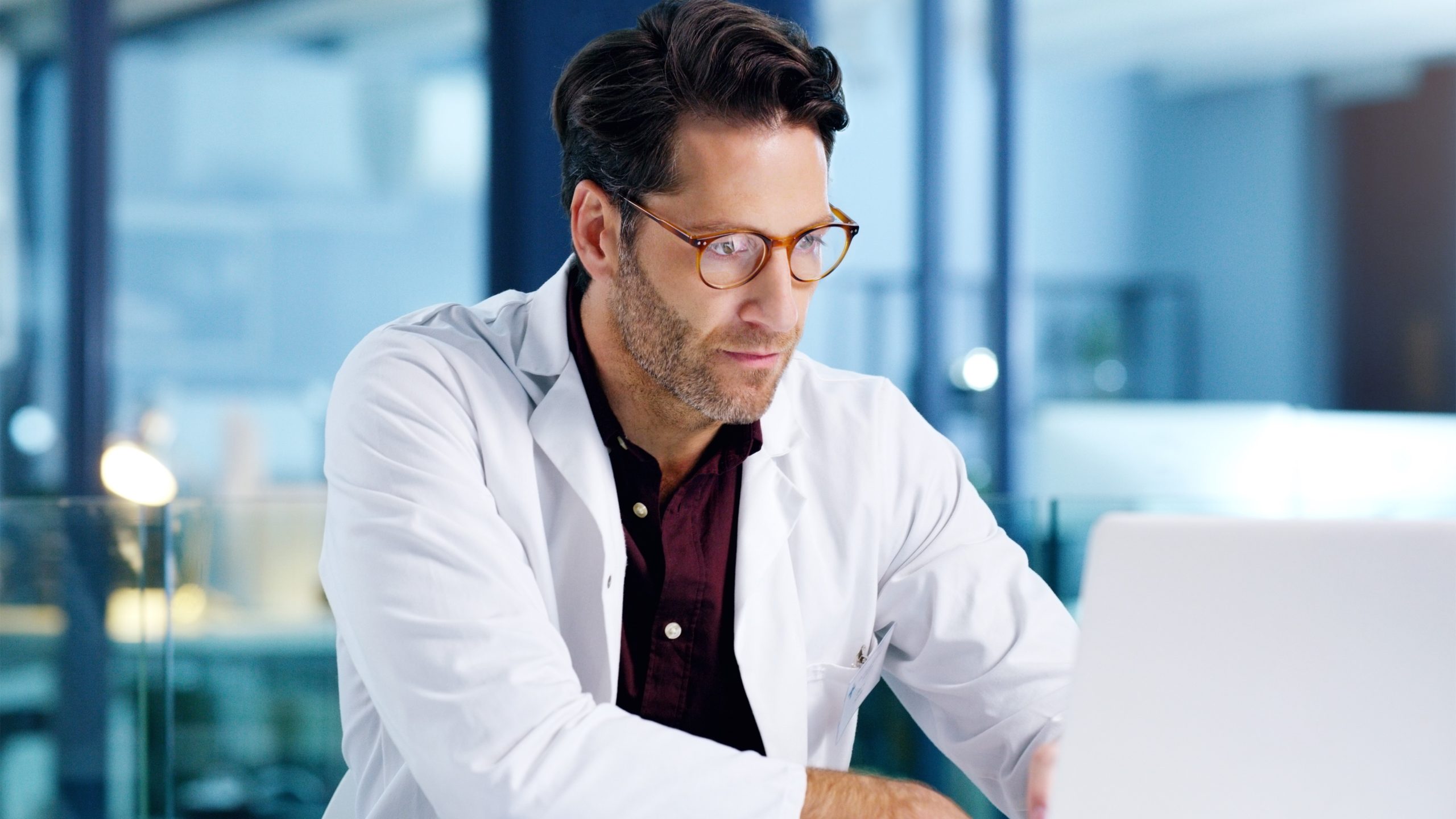 Male doctor working on his computer at the office.