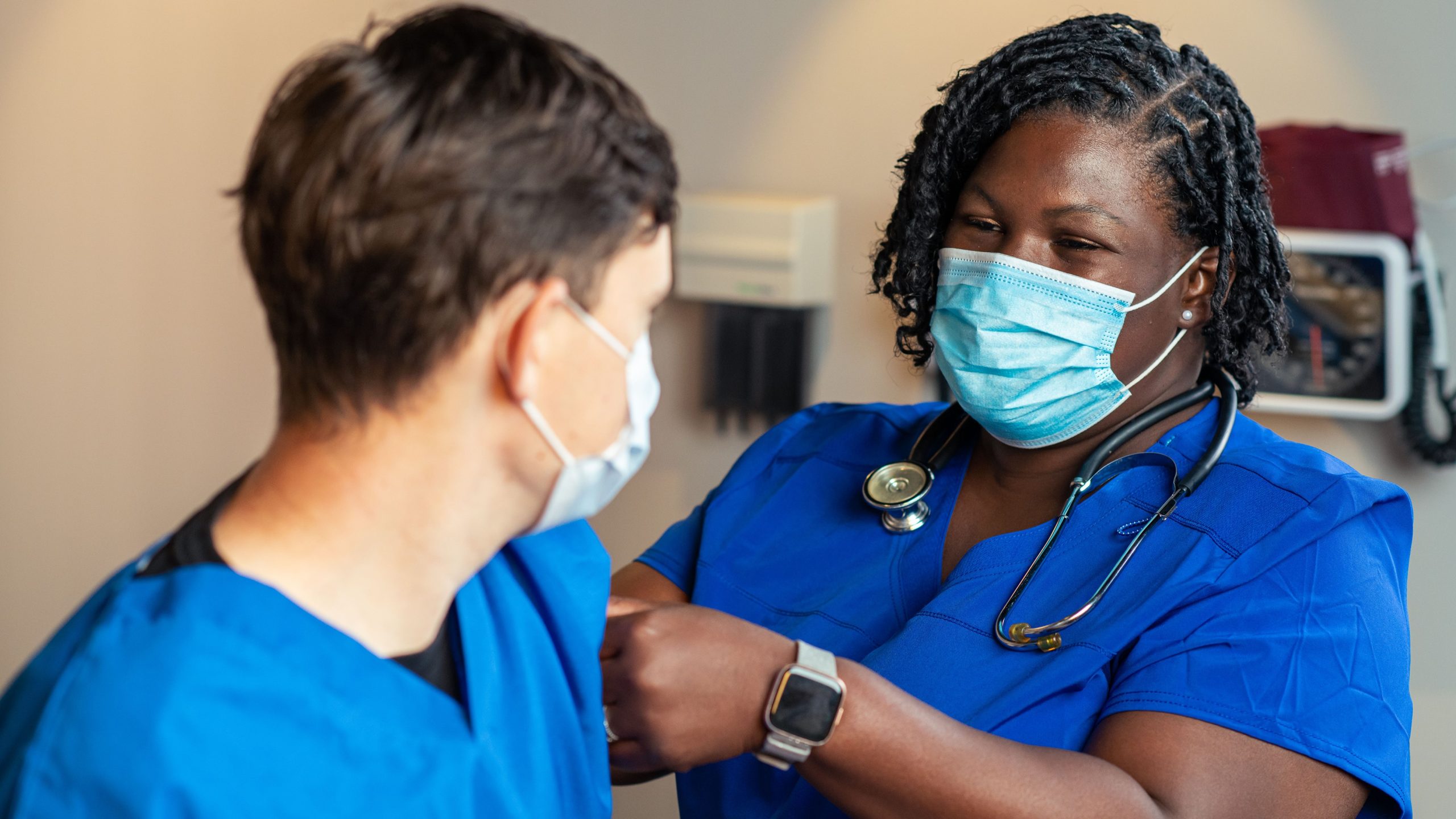 Female healthcare provider placing a bandage on a patient's arm.