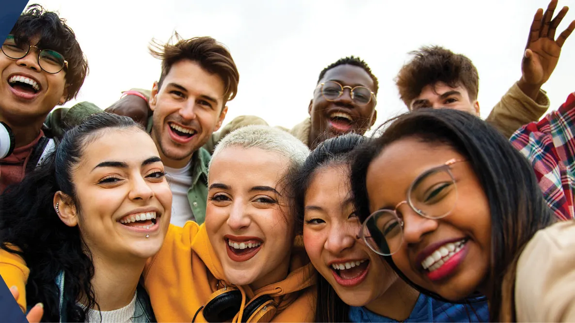 A group of multiracial teenagers, smiling and laughing.