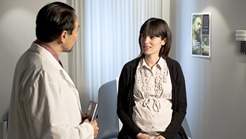 Pregnant woman talking with her male healthcare provider.